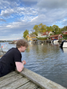 Student leaning over pier
