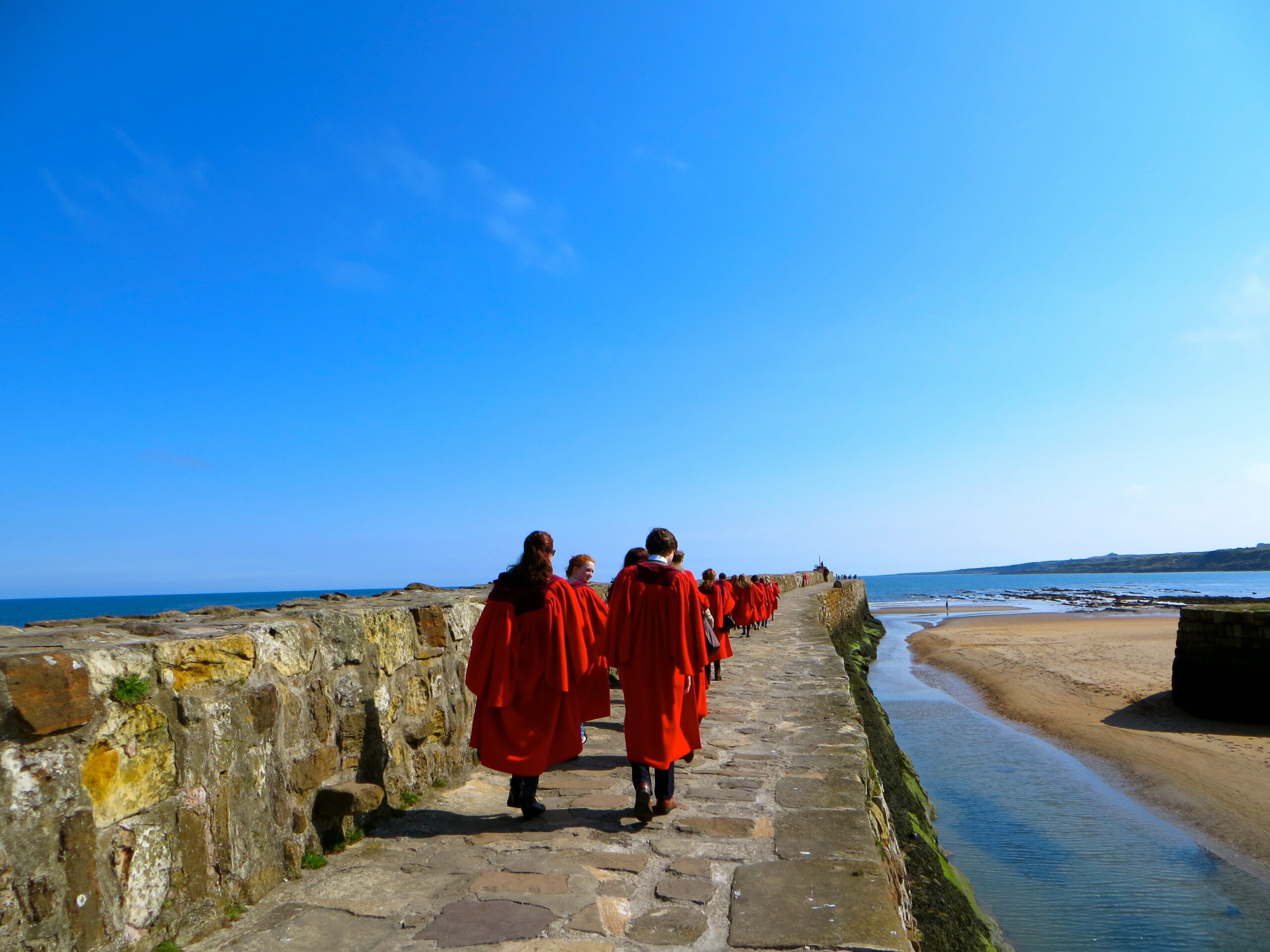 New students embrace one of the University of St Andrews' traditions by taking part in the annual Pier Walk while wearing their red gowns.