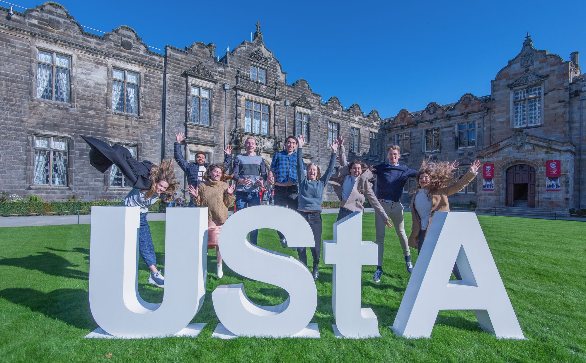 Students posing with University of St Andrews sign. 
