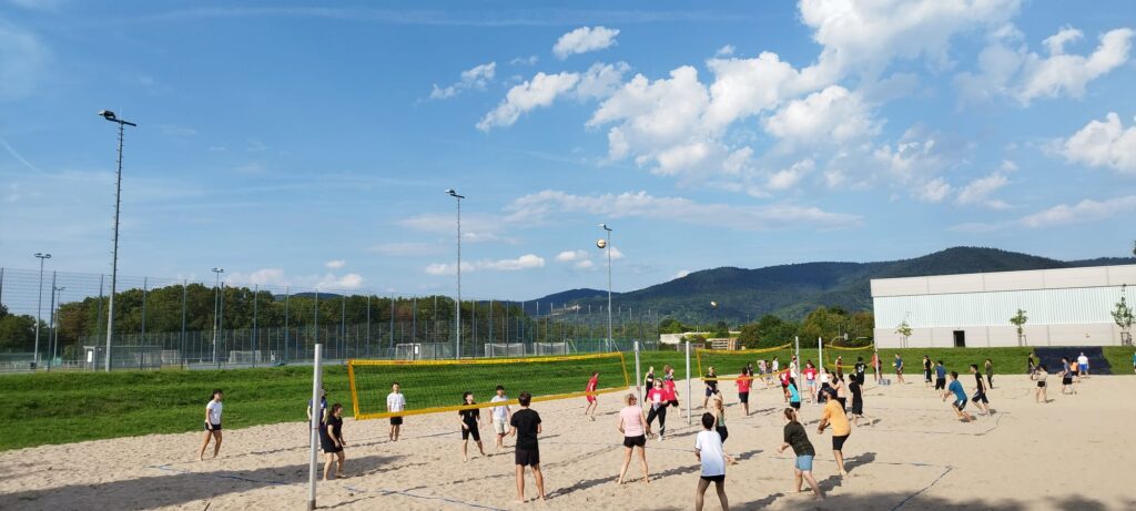 A group of students playing beach volleyabll