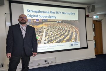 Man in suit in front of screen
