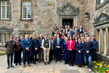 Group of fifty people in front of historic buildings