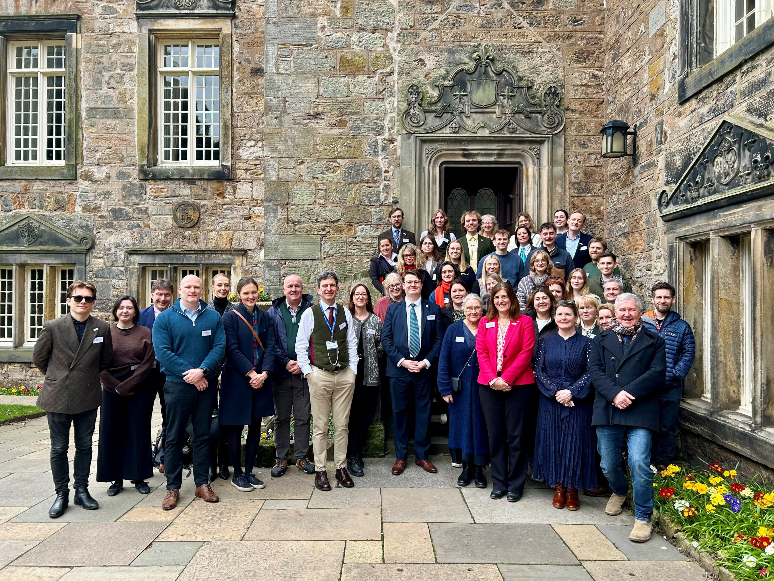 Group of fifty people in front of historic buildings